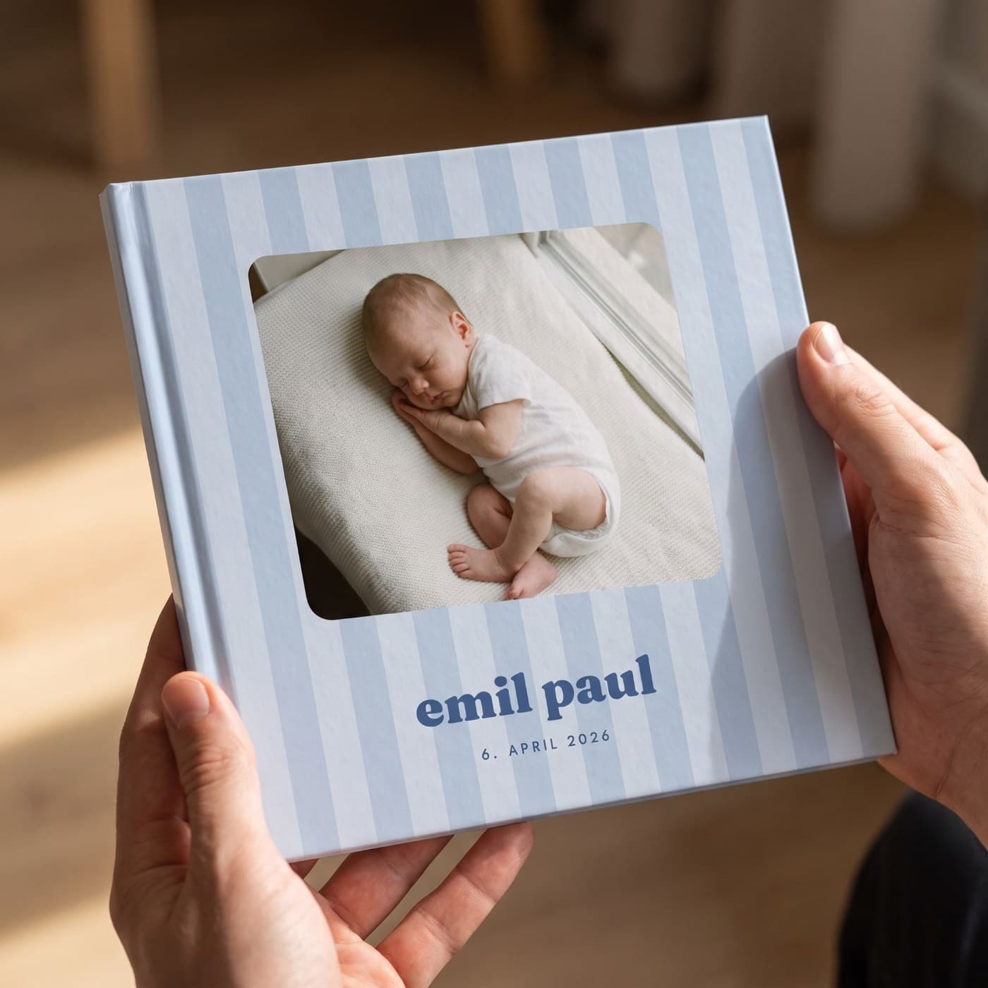 „Babyalbum Junge" in zwei Händen, Nahaufnahme des Umschlags