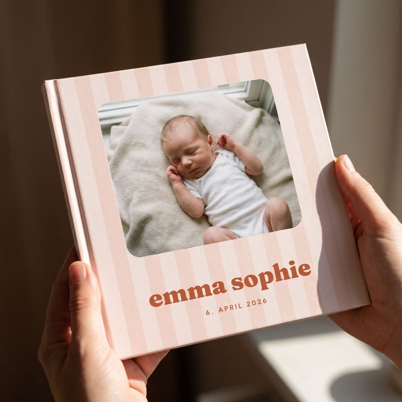 „Babyalbum Mädchen" in zwei Händen, Nahaufnahme des Umschlags