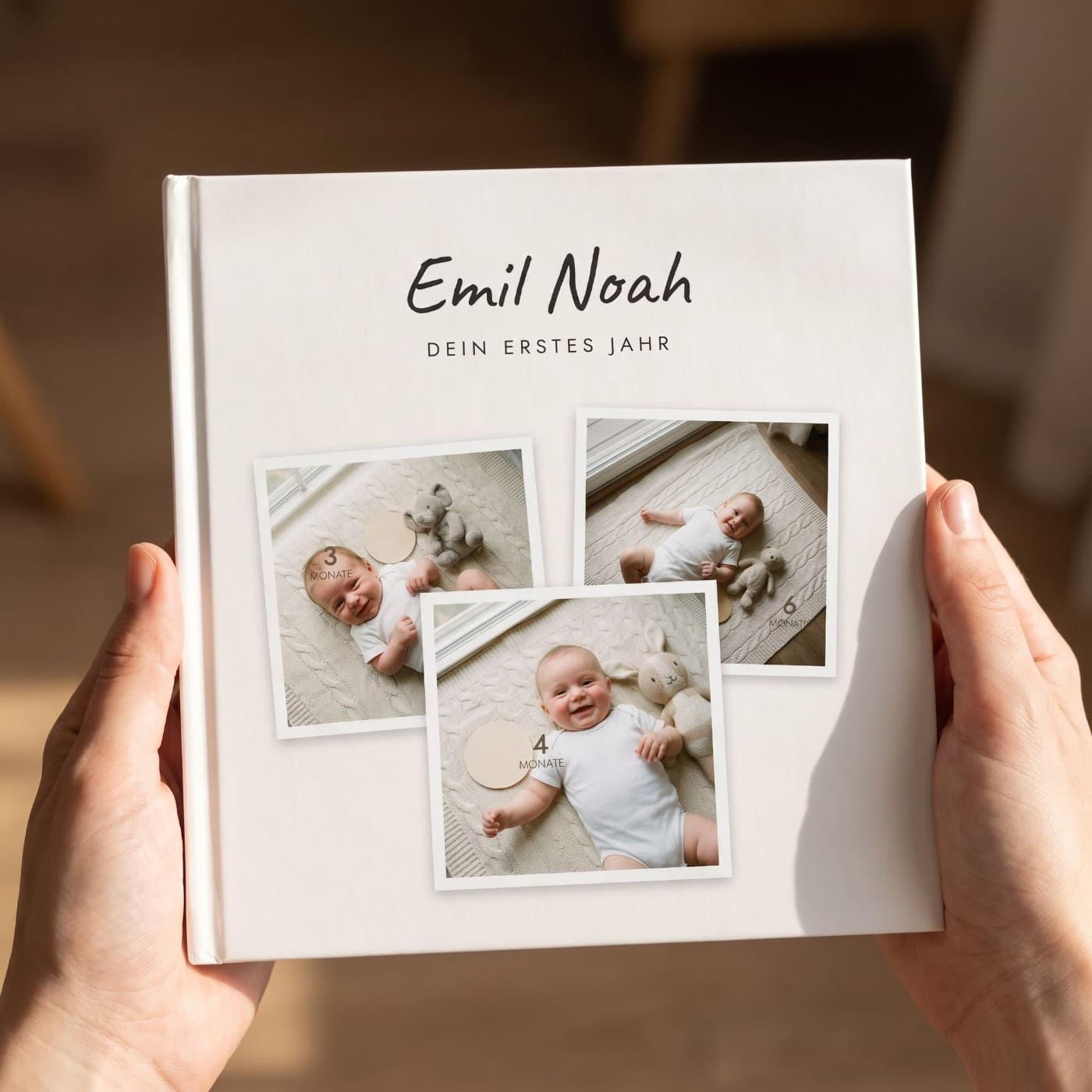 „Dein erstes Jahr (Polaroid)" in zwei Händen, Nahaufnahme des Umschlags
