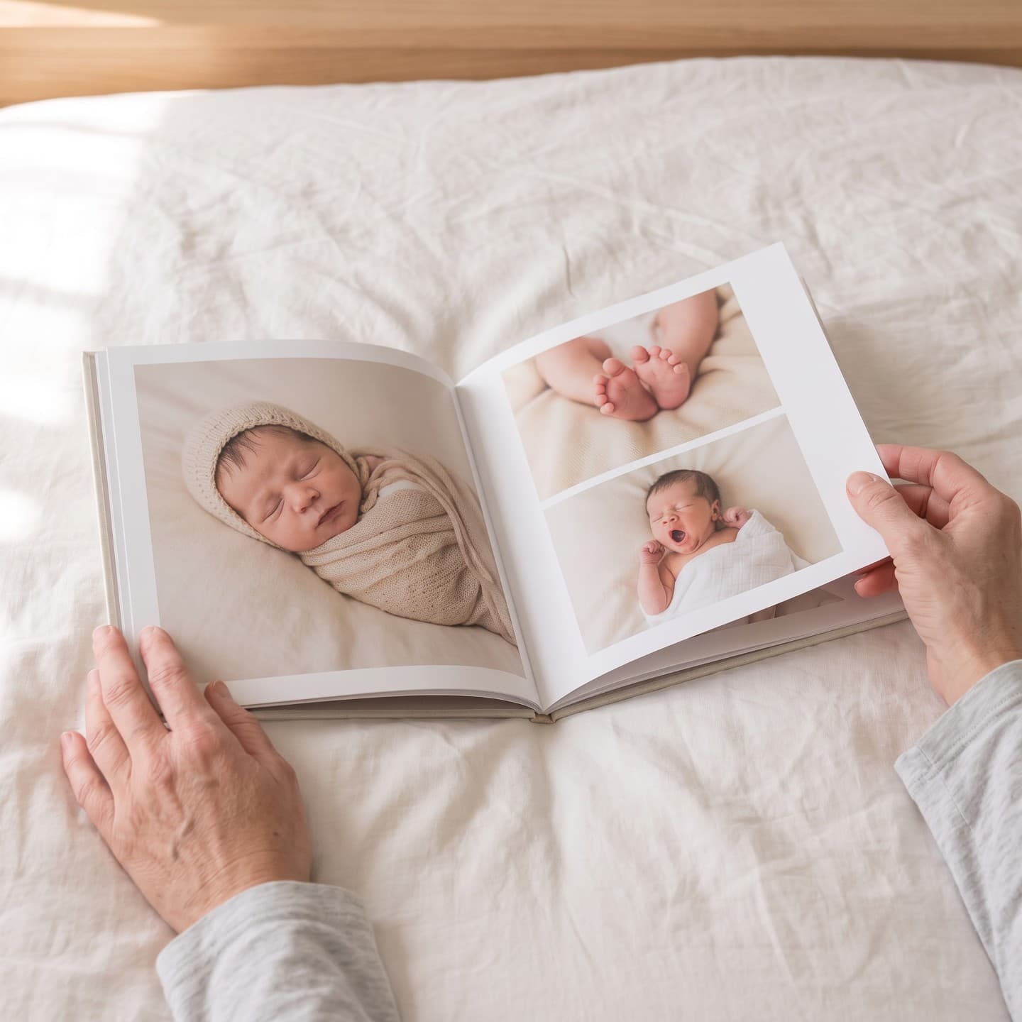 Atvērts mazuļa albums uz gultas: baltas lappuses, jaundzimušā fotogrāfijas ar apmali